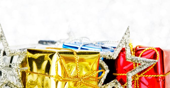 Decorated holiday gifts on silver background