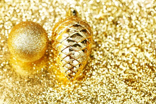 Golden christmas balls on shining glitter background close-up