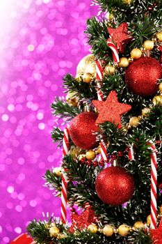 Beautiful decorated christmas tree on glitter purple background