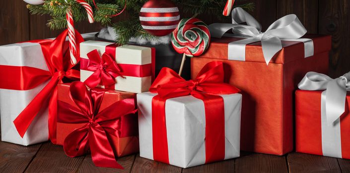 Decorated Christmas gifts under tree with candy canes and striped baubles