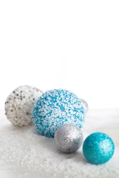 Christmas decoration of colorful glitter balls and snow on wooden background with copy space for text new year card concept