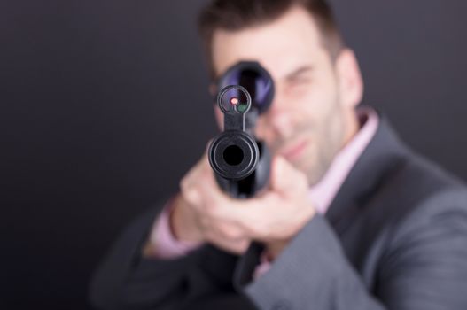 Man in suit with rifle and scope, isolated on black