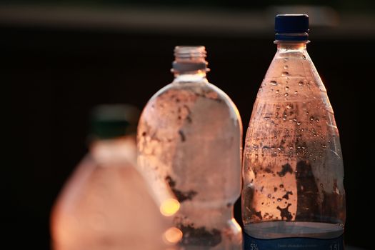 Brown plastic bottles with water drops. Focus on the right bottle.