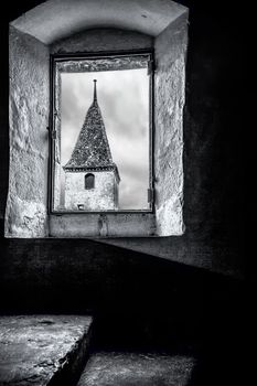 This image is taken from within one of the towers of the Castle of Gruyere looking out at another corner and tower of the Chateau The Chateau is situated in the medieval town of Gruyeres, Switzerland. It is a Swiss heritage site of significance and is home to the famous Gruyere Cheese.