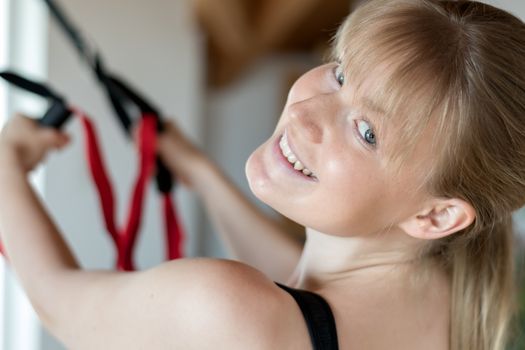 Smiling girl in sling training at home