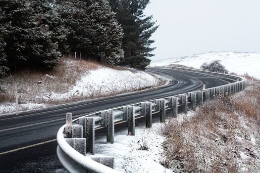 Curving highway through snow covered hills in winter