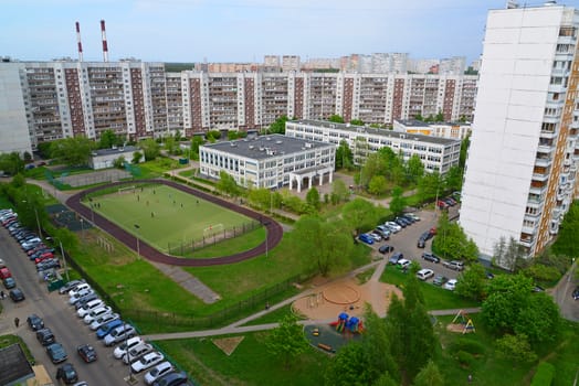 City landscape with school and a football field in summer in Moscow, Russia