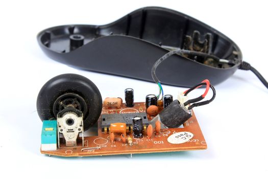 An old mouse with a wheel opened to show the technology used in it.