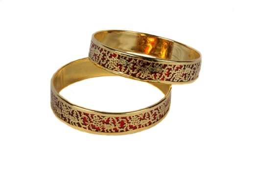 Traditional Indian bangles with an intricate design in gold on crimson color.