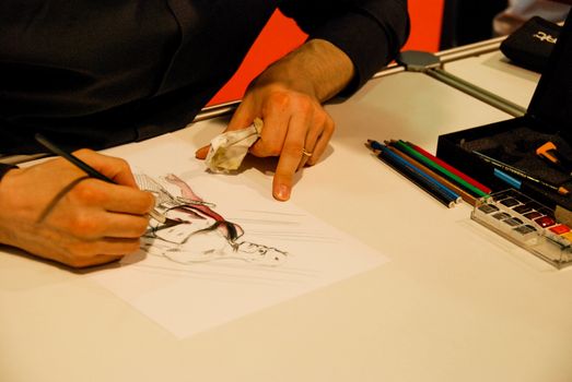 Cartoonist draws with watercolor paintbrush