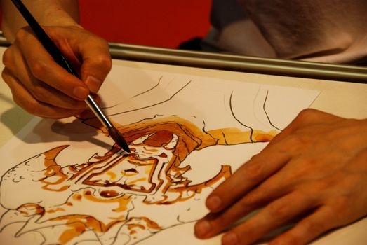 Cartoonist draws with watercolor paintbrush