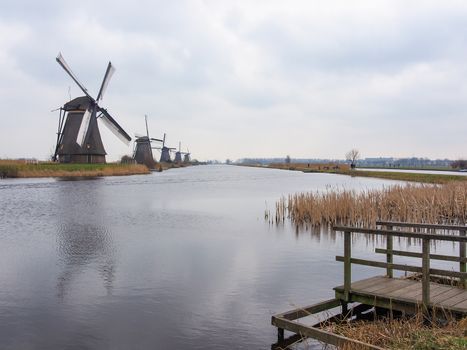 Netherlands rural landscape with windmills and canal at famous tourist site Kinderdijk in Holland