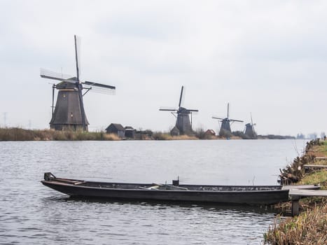 Netherlands rural landscape with windmills and canal at famous tourist site Kinderdijk in Holland