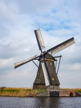 Netherlands rural landscape with windmills and canal at famous tourist site Kinderdijk in Holland