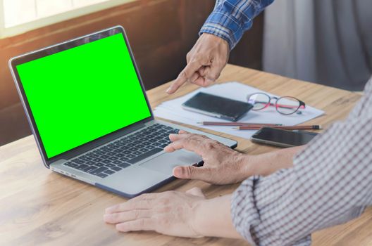 businessman using laptop computer with green screen in office. hipster tone