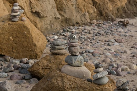 Stones stacked on top of each other on the beach on the Baltic Sea with so-called chicken gods.