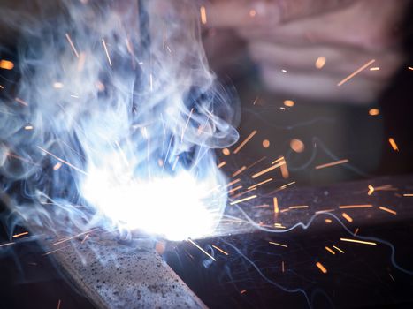 Close-up of electric welding spot producing high temperature and sparks