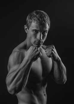 Young shirtless fit fighter doing shadow boxing