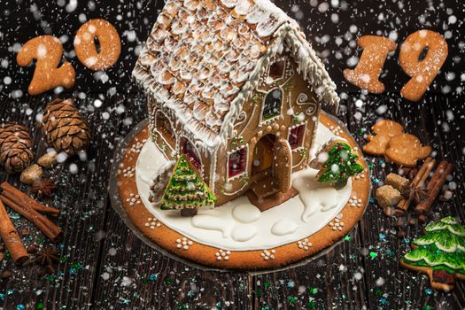 Gingerbread house and figures with lights on dark background, xmas theme