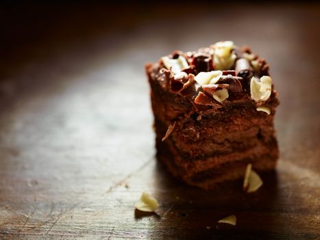 A closeup of a delicious piece of chocolate cake on a wooden table.