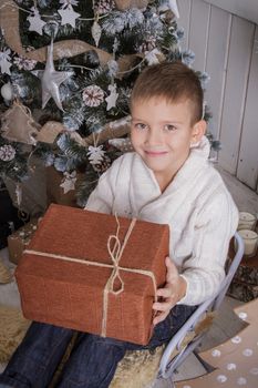 Smiling boy with Christmas gift on sleigh