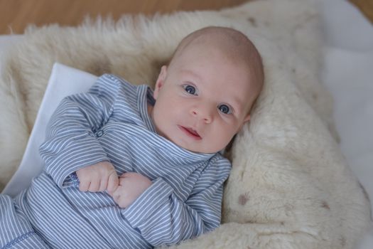 Cute one month baby boy lying, big blue eyes