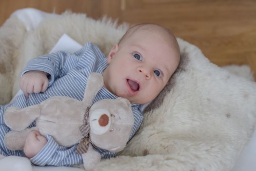 Cute one month old baby boy lying with teddy bear