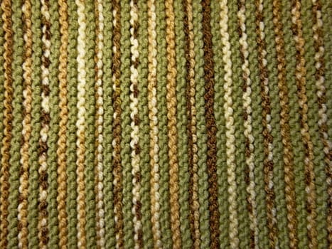 Knitted fabric texture. Background image. Hobbies, leisure, crafts. Vertical arrangement of the pattern. Green and brown