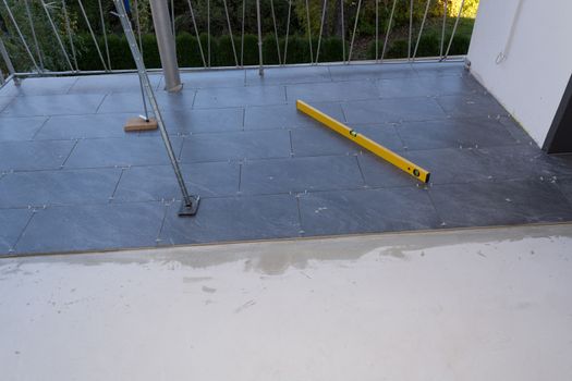 Balcony floor tiles installation. Laying tiles from porcelain. Interior remodeling theme.