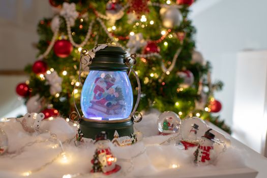 Christmas decoration, snow dome, globe with table decoration, Santaclaus on sleigh with child in winter scene with snowflakes, reindeer snowglobe and polar bears, tree in background