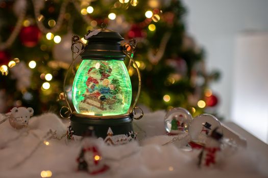 Christmas decoration, snow dome, globe with table decoration, Santaclaus on sleigh with child in winter scene with snowflakes, reindeer snowglobe and polar bears, tree in background