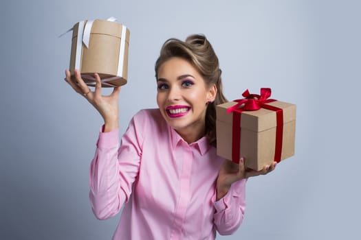 Young happy woman holding two presents with bows
