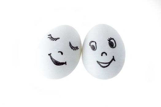 Funny white eggs imitating a couple of happy smiling lovers on white background