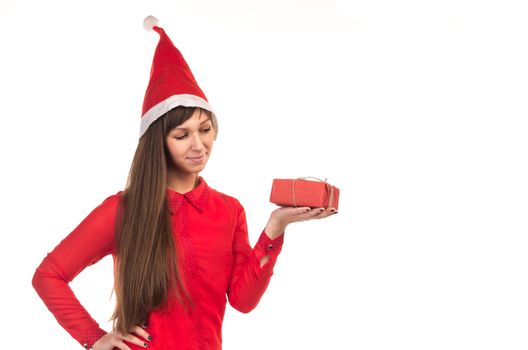 Young long-haired woman in red christmas cap holds red gift box