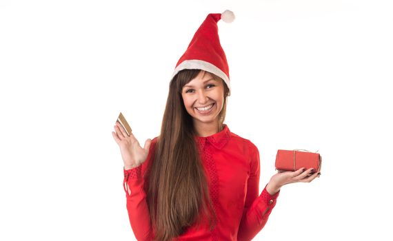 Young long-haired woman in red christmas cap with gold credit card and red gift box