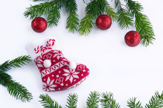 Red Christmas stocking and decoration balls on white background, frame of green contiferous fir tree branches