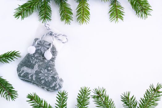 Gray Christmas stocking sock on white background, frame of green fir tree branches