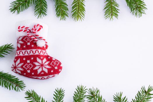 Red Christmas sock on white background, frame of green contiferous fir tree braches