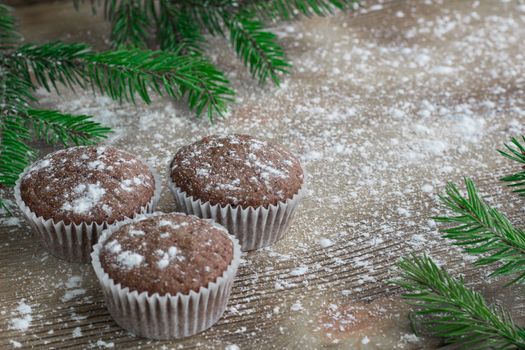 Christmas and New Year winter holiday composition of three cakes on snowbound wooden space background with green fir tree branches