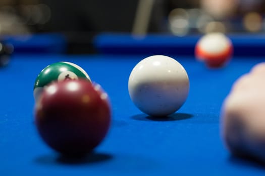 Billiard pool game in progress, balls are on blue table cloth