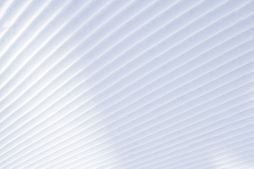 Background of diagonal geometrical parallel stripes of snow with light shadow