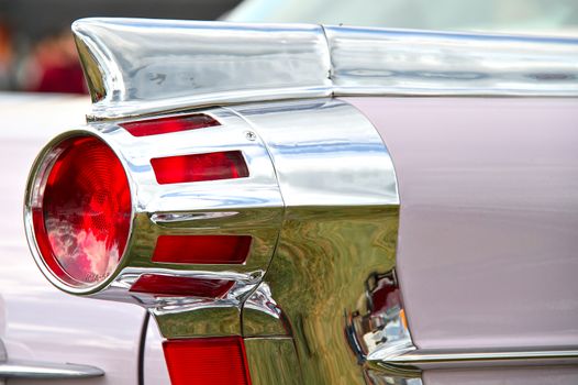 Round taillight of an old american car decorated with chrome.