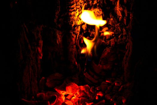 Fire getting darker as all the wood is burned to ashes. Closeup photo of inside the fireplace.