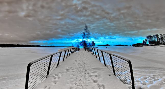 HDR landscape photo of small bridge on frozen sea. Red and blue channels swapped