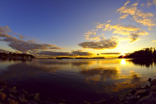 Stunning mid summer sunset by the water. Sunset reflecting from the surface.