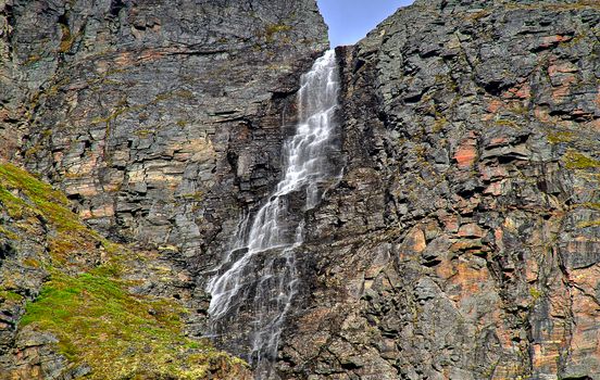 Snow melting water falling from the top of Norwegian fjord.