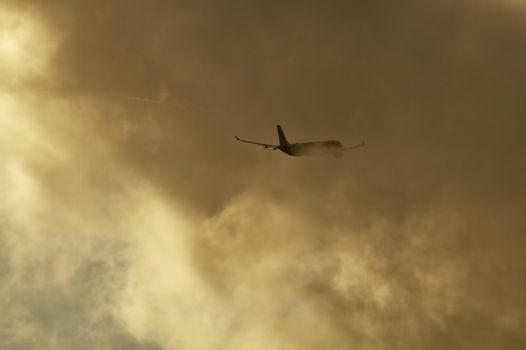 Commercial airplane disappears as it enters into the huge clouds.