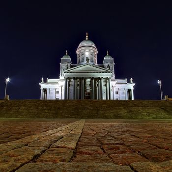 Low angle photo of Helsinki Cathedral at night. Old stone pavement on foreground