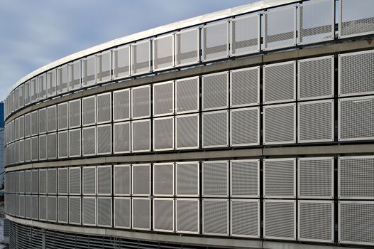 Round shaped parking lot, four floors. Shiny steel net walls.