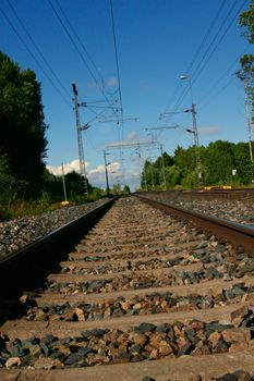 Tilted view of empty railway. Power lines hanging above.